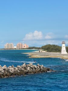 Blue ocean with Atlantis in the background and a light house to the right side of picture. 