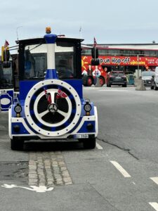 Blue train = City Train & Red Bus In Background is the Hop On / Off Bus